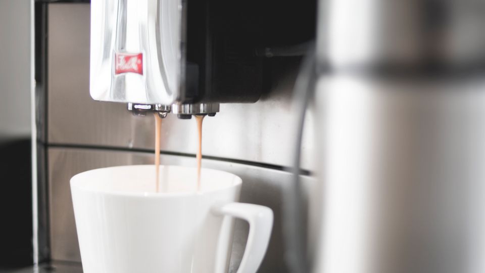 Espresso die uit de uitloop van een machine stroomt